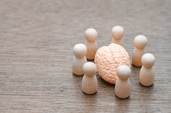 The Power of the Mastermind: A team of peg figures surrounds a central brain model, representing a collective focus or a brainstorming session.