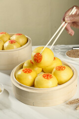 Chinese Steamed Pumpkin Buns in Bamboo Steamer with Chopsticks - Traditional Asian Cuisine