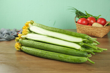 Fresh Long Loofah Gourds and Cucumbers from Shouguang Shandong China on Wooden Table with Tomatoes