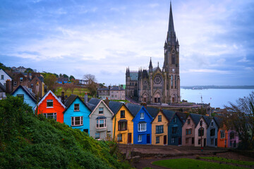 Cobh skyline with the towering Cobh Cathedral and colourful Deck of Cards houses in County Cork, Ireland, a vibrant hilltop cityscape of the historic port once known as Queenstown.