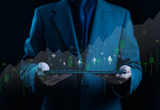 Businessman using digital tablet analyzing stock market data and financial growth chart with virtual technology representing investment strategy, economic success, and data-driven business innovation.