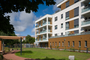 Modern apartment building with a green courtyard and wooden pergola