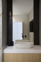 Modern bathroom interior with a white vessel sink and large mirror