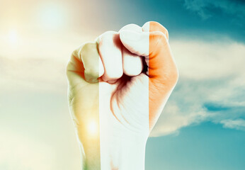 Ireland national flag fist raise in the sky. The hand with flag raise in beautiful soft sky....