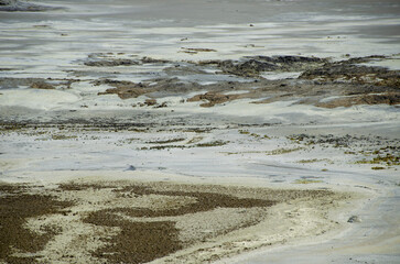 Detailed view of a dry, barren, and mineralized landscape, showing white salt and chemical deposits characteristic of an abandoned copper mine or industrial tailings.