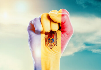Moldova national flag fist raise in the sky. The hand with flag raise in beautiful soft sky. Moldova national flag for independence day.