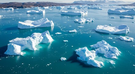 Aerial view showcases a vast ocean dotted with striking, majestic icebergs, under clear sky