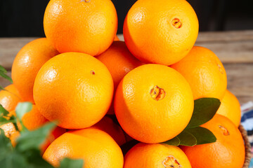 Fresh Navel Oranges Pile with Green Leaves on Wooden Background