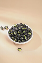Black beans with green sprouts in ceramic bowl - healthy legume food ingredient