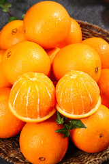 Fresh Sweet Navel Oranges in Wicker Basket with Peeled Segments Showing Juicy Citrus Fruit