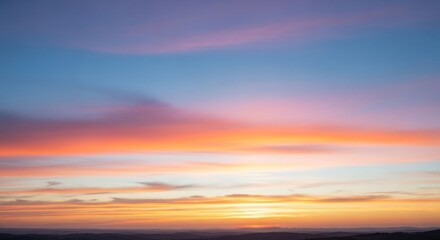A vibrant sunset with a colorful sky and clouds, featuring a mix of warm and cool tones, with a mountain range in the background.