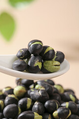Roasted Black Beans with Green Five Spice Seasoning on White Spoon - Crispy Fried Legumes with Salt and Herbs