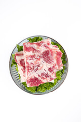 Raw Pork Belly Slices with Skin On for Chinese BBQ - Fresh Marbled Meat on Lettuce Garnish