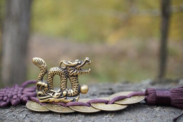 A dragon statuette with Chinese coins. Religion and culture.