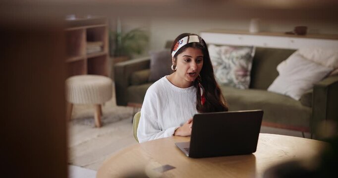 Indian woman, talking and video call with laptop for communication, proposal or speech in living room at home. Female person, journalist or influencer speaking on computer for online tutorial or tips