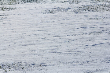 Snowy landscape with undisturbed surface under bright sunlight during winter