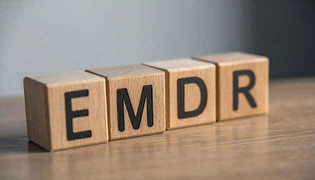 Wood cubes with abbreviation EMDR on table. Eye Movement Desensitization and Reprocessing.