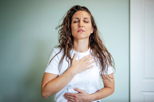 Woman practicing mindfulness and deep breathing for relaxation indoors