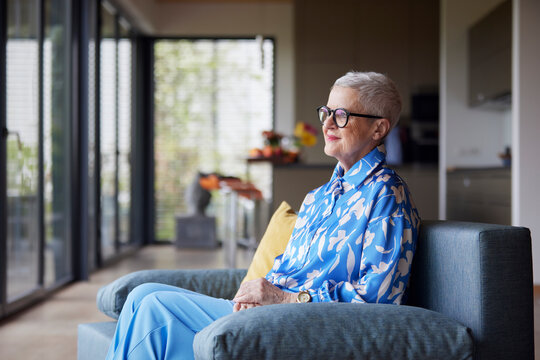 Senior woman sitting on couch at home