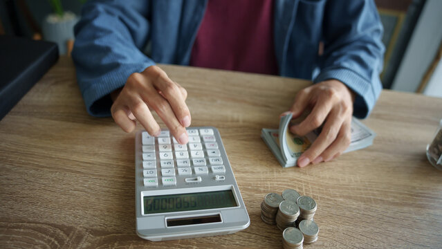 Man calculates finances by calculator Count banknotes and coinsใ