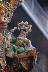 Close-up of a richly adorned statue of the Virgin Mary holding Baby Jesus during a traditional Granada procession. devotion, tradition