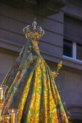Back view of a statue of the Virgin of the Rosary in Granada during a religious procession, wearing an ornate crown and embroidered mantle. tradition, devotion