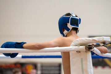Kickboxer in blue gear resting in the corner before the fight