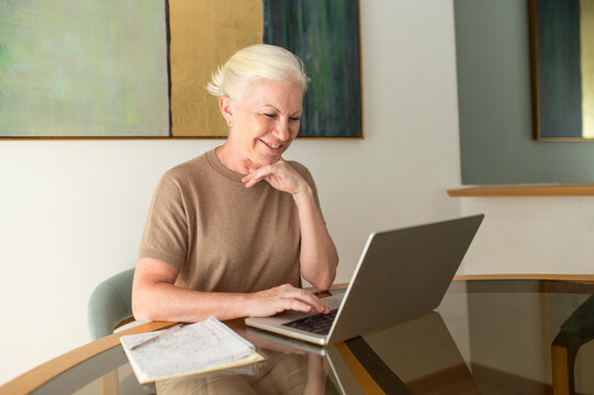 Entrepreneur smiling while working on laptop in elegant office