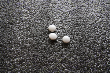 three pills on a gray background,