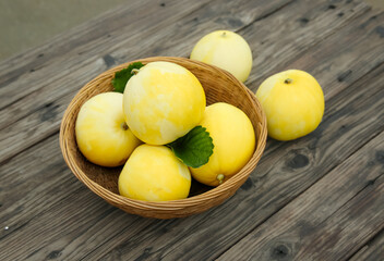 Fresh Sweet Fragrant Melons in Wicker Basket on Rustic Wooden Table