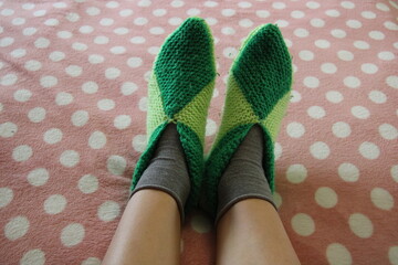 knitted slippers and socks on women's feet, feet,