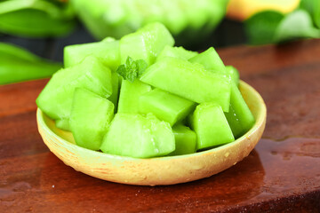 Fresh Green Honeydew Melon Cubes in Wooden Bowl - Healthy Summer Fruit Snack on Rustic Wood Table
