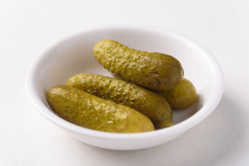 Fresh pickled gherkins cucumbers on white background