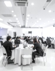 Blurry business meeting, white table, people in suits
