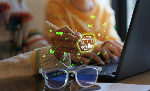 Environmental and sustainability concept, Woman working with computer analyzing data with environmental impact, renewable energy, air pollution reduction targets and carbon emissions with graph