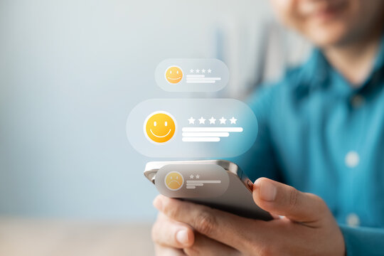 Satisfaction customer giving positive feedback on mobile phone with five-star rating and smiling emoji. Concept of user experience, and online review system, excellent products and service.