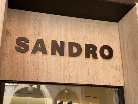 Palma De Mallorca, Spain - October 30, 2025: Sandro brand storefront sign displayed prominently on a textured stone wall, showcasing modern retail design and branding aesthetics