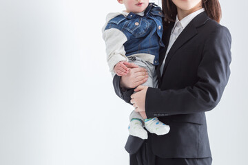 赤ちゃんを抱いたスーツの女性