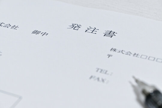 「発注書」の見出しが写った日本語のビジネス書類とペン