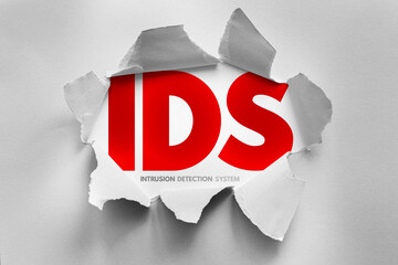 Torn paper reveals bold IDS letters with the words Intrusion Detection System below. Modern design concept representing cybersecurity, monitoring, alert systems, and digital protection
