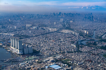 Obraz premium Dense northern Jakarta coastline seen from above, showing rapid urban expansion along the shore as rising sea levels and climate risks threaten low lying districts and future city resilience.