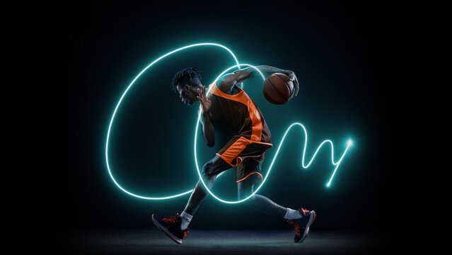 Basketball player dribbling with glowing neon trail symbolizing energy and speed. Concept of dynamic sports advertising, motion graphics, and digital brand identity.