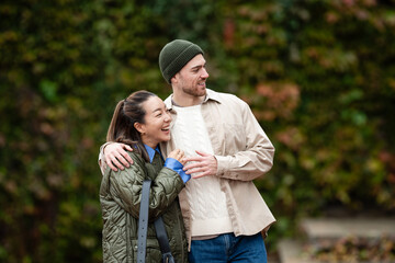 Happy diverse couple laughing embracing outdoors