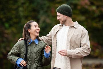 Happy young diverse couple talking walking outdoors