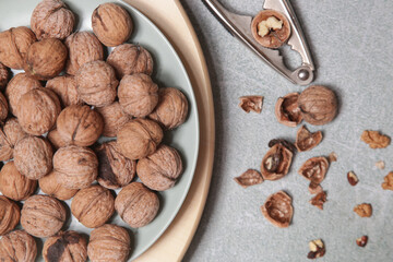 Whole and cracked walnuts and nutcracker	