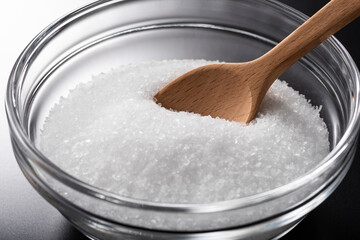 ガラスの器に入った食塩と木製スプーン