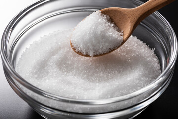 ガラスの器に入った食塩と木製スプーン