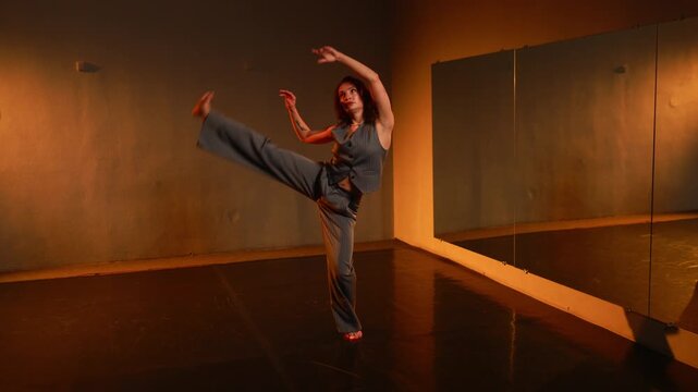 Young woman performs contemporary dance in an empty studio
