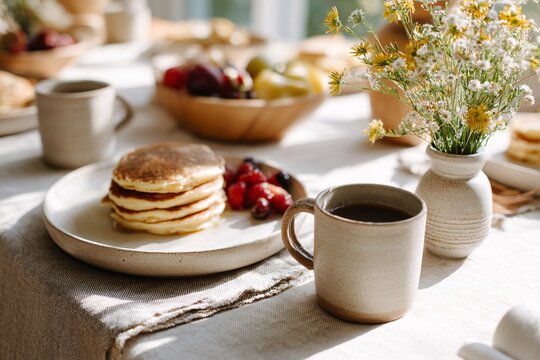 Family enjoying breakfast together with pancakes and fresh fruit