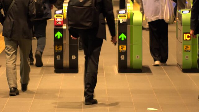 TOKYO, JAPAN - NOV 2025 : Automatic ticket gate at the train station. Crowd of people passing through the gate in busy rush hour. Japanese urban city life, transportation, traffic and commute concept.